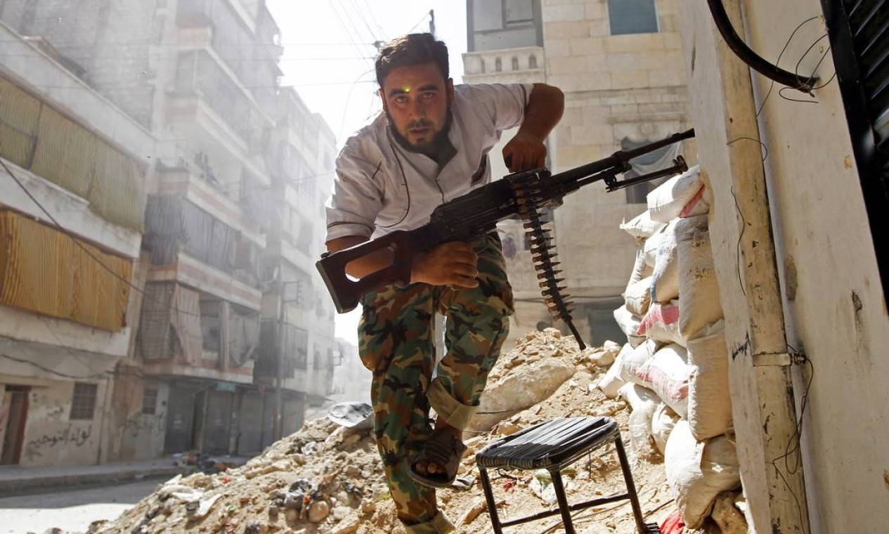 Combatente do Exército Livre da Síria tenta se proteger de combates no bairro de Salaheddine em 2012 Foto: GORAN TOMASEVIC / REUTERS