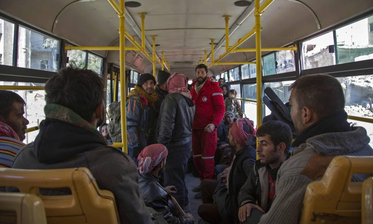 Funcionário do Crescente Vermelho na Síria trabalha em ônibus que leva rebeldes e suas famílias para fora de bairros insurgentes de Aleppo Foto: KARAM AL-MASRI / AFP