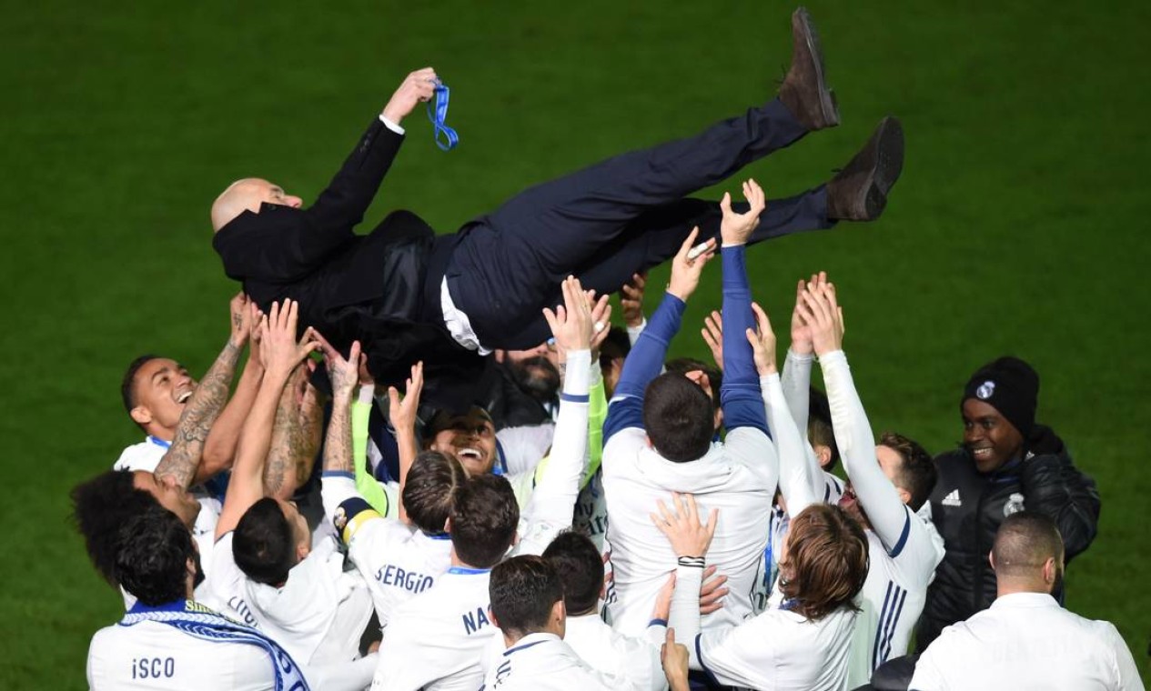 Jogadores do Real Madrid jogam para o alto o técnico Zinedine Zidane: em 2016 o time conquistou a Liga dos Campeões da Europa e o Mundial de Clubes, no Japão Foto: TORU YAMANAKA / AFP