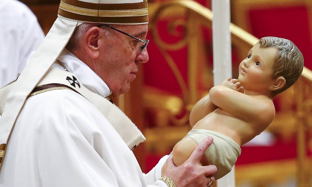 Foto do Papa Francisco segurando uma pequena imagem do Menino Jesus, durante a Missa de Natal, em 2018.