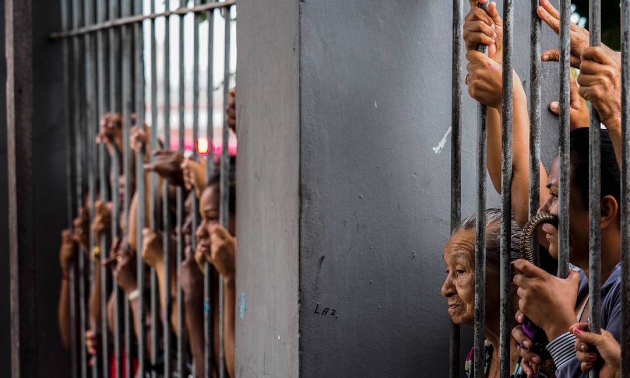 Pessoas aguardam em frente ao presídio Raimundo Vidal Pessoa, em Manaus, informações sobre seus parentes presos Foto: RAPHAEL ALVES / AFP
