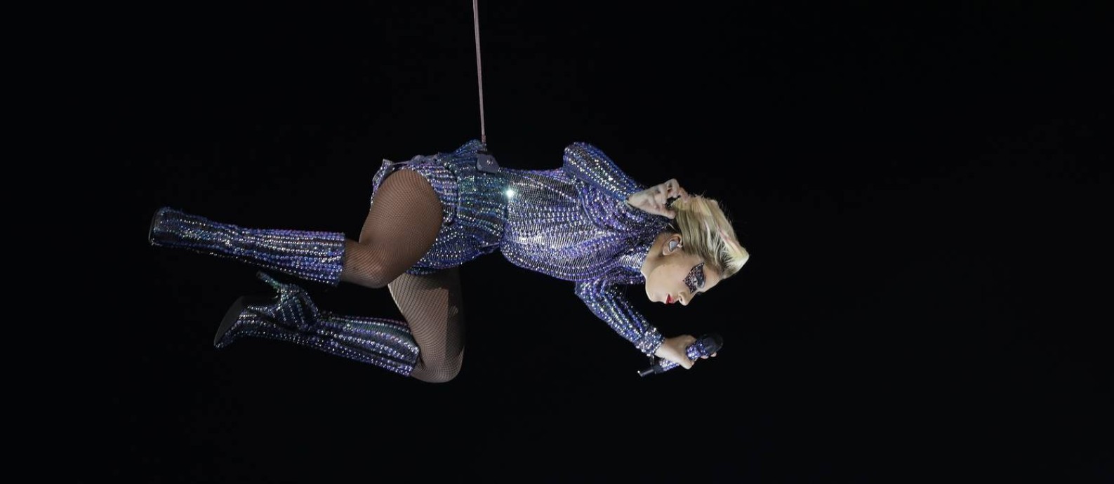 Lady Gaga desce do teto do NRG Stadium através de cabos para fazer sua apresentação no intervalo do Super Bowl 51 Foto: Mark Humphrey / AP