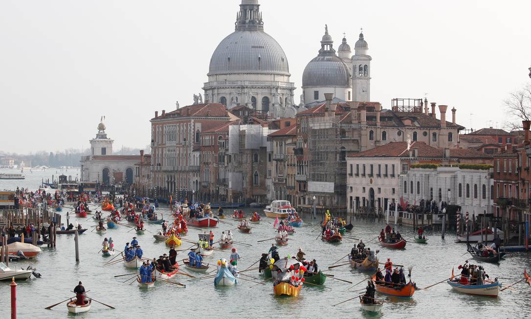 Dezenas de mascarados desfilaram em gôndulas pelo Grande Canal de Veneza, neste domingo TONY GENTILE / REUTERS