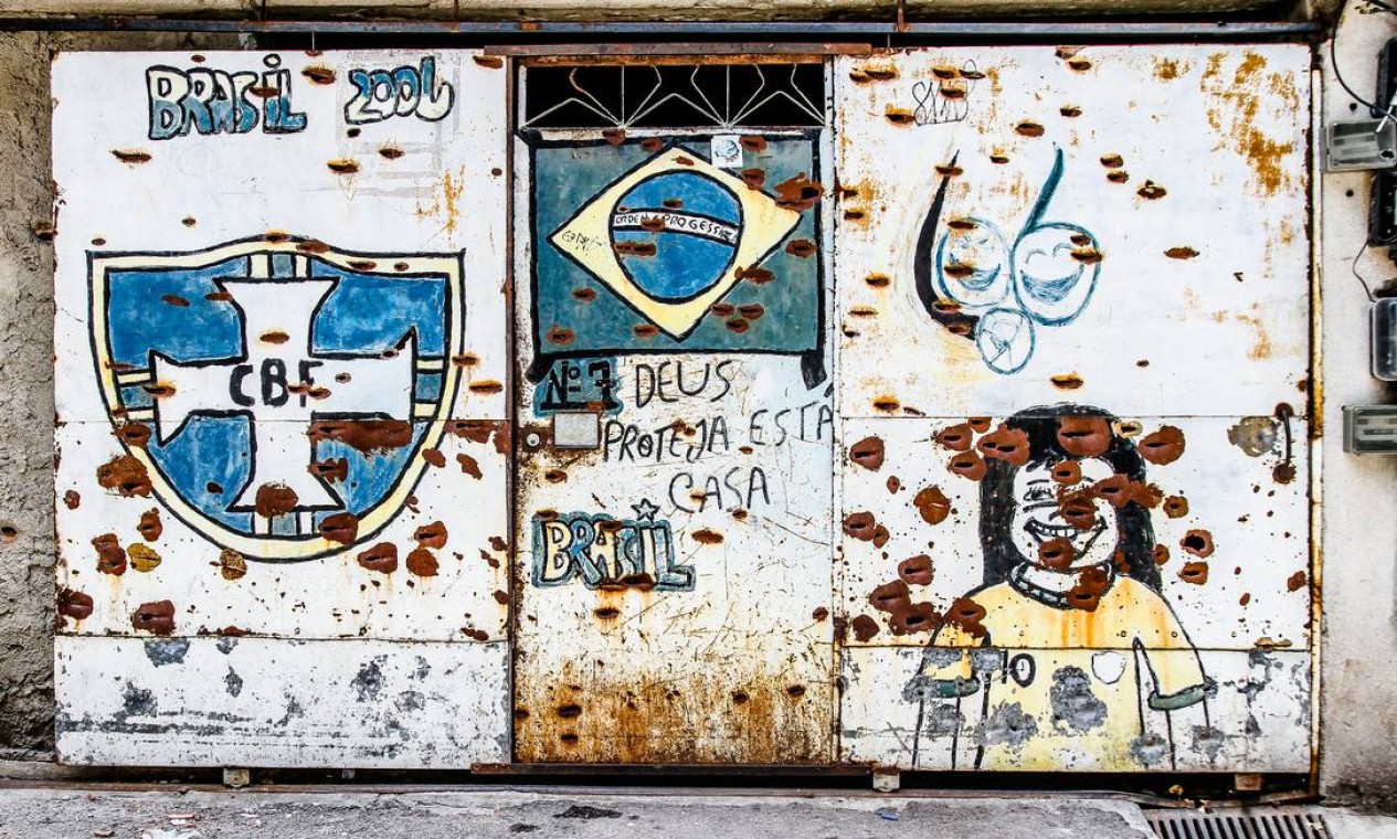 Em portão com tiros antigos, lê-se a frase "Deus projte esta casa" Foto: Bruno Itan / Divulgação