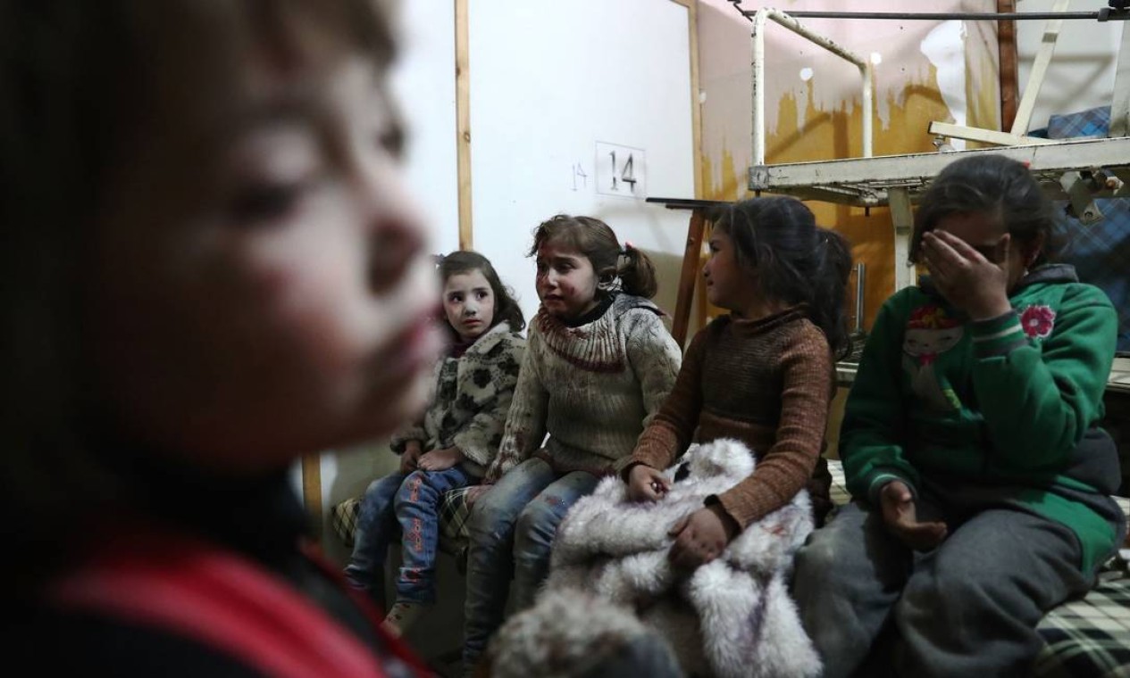 Meninas choram após serem atingidas por ataque aéreo do regime de Bashar al-Assad; relatório do Unicef diz que, no ano passado, não houve diminuição de ataques a escolas, hospitais, parques e casas Foto: ABD DOUMANY / AFP