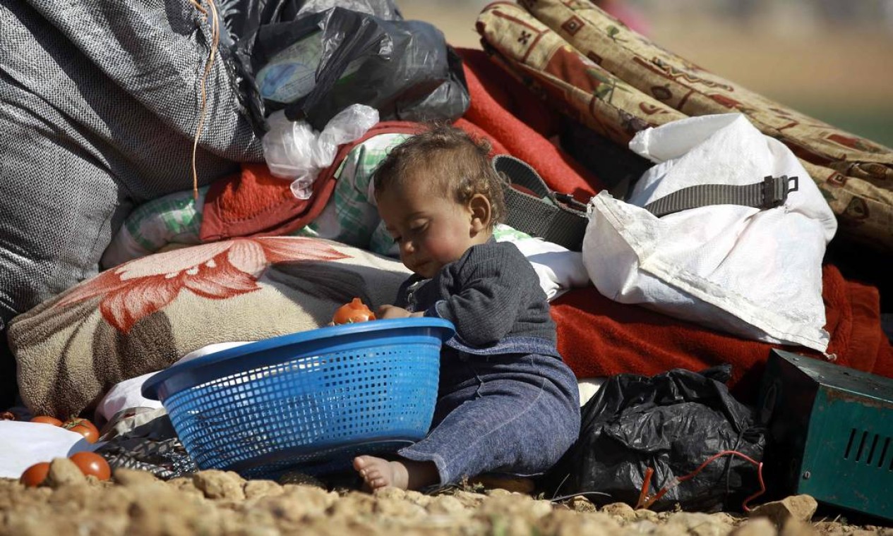 Bebê senta no chão de campo para deslocados perto da cidade de Mabij; famílias de Aleppo, cidade devastada pela guerra, se dirigem para lá em busca de segurança Foto: DELIL SOULEIMAN / AFP