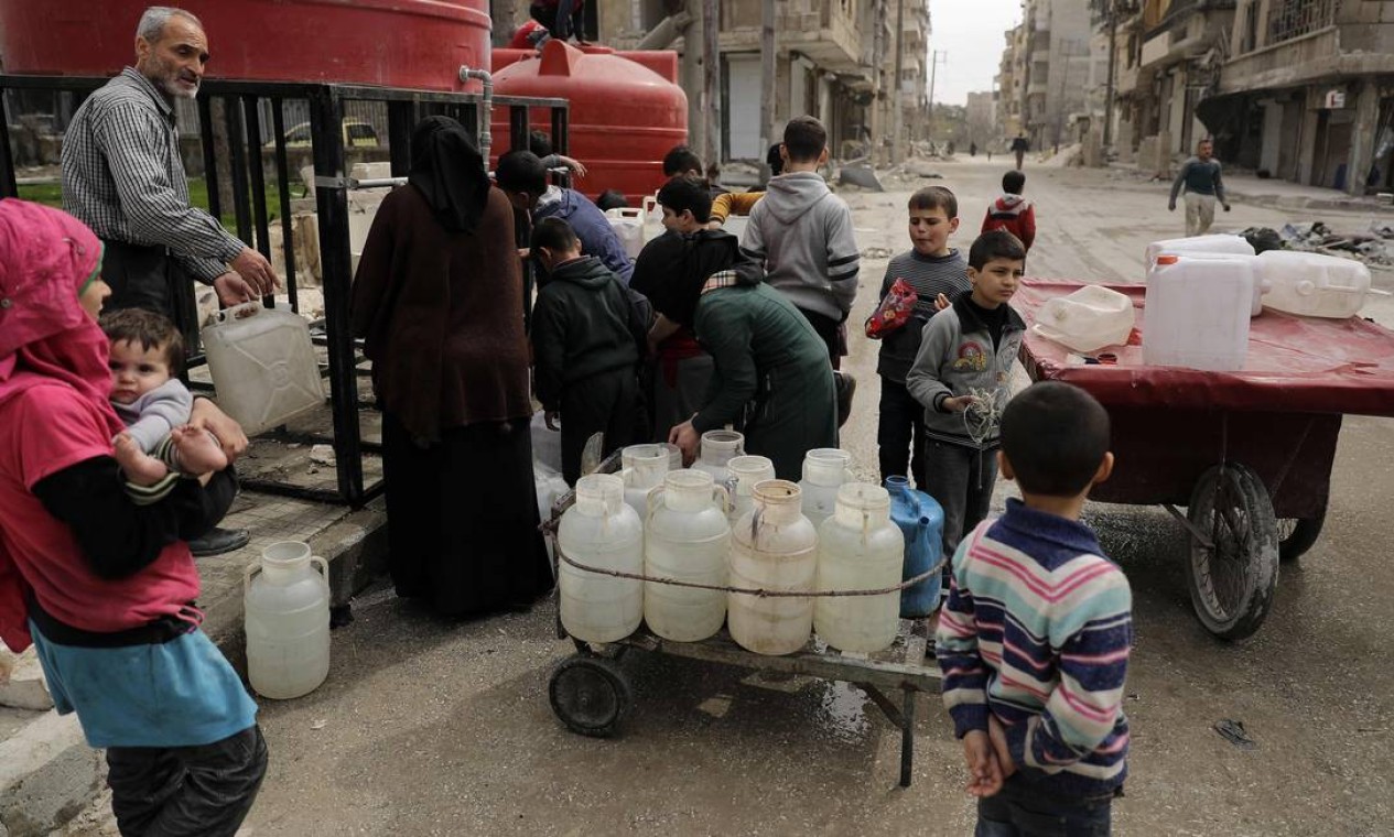 Crianças sírias formam fila em reservatório de água no bairro de Shaar, em Aleppo, que já foi controlado por rebeldes Foto: JOSEPH EID / AFP