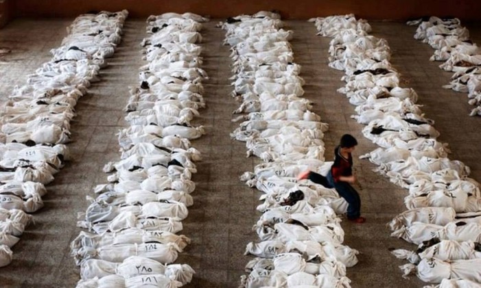 Menino passa por cima de corpos de crianças mortas em ataque químico em Ghouta, na Síria, em 2013: ataque deixou centenas de mortos, e número é incerto até hoje Foto: Reprodução