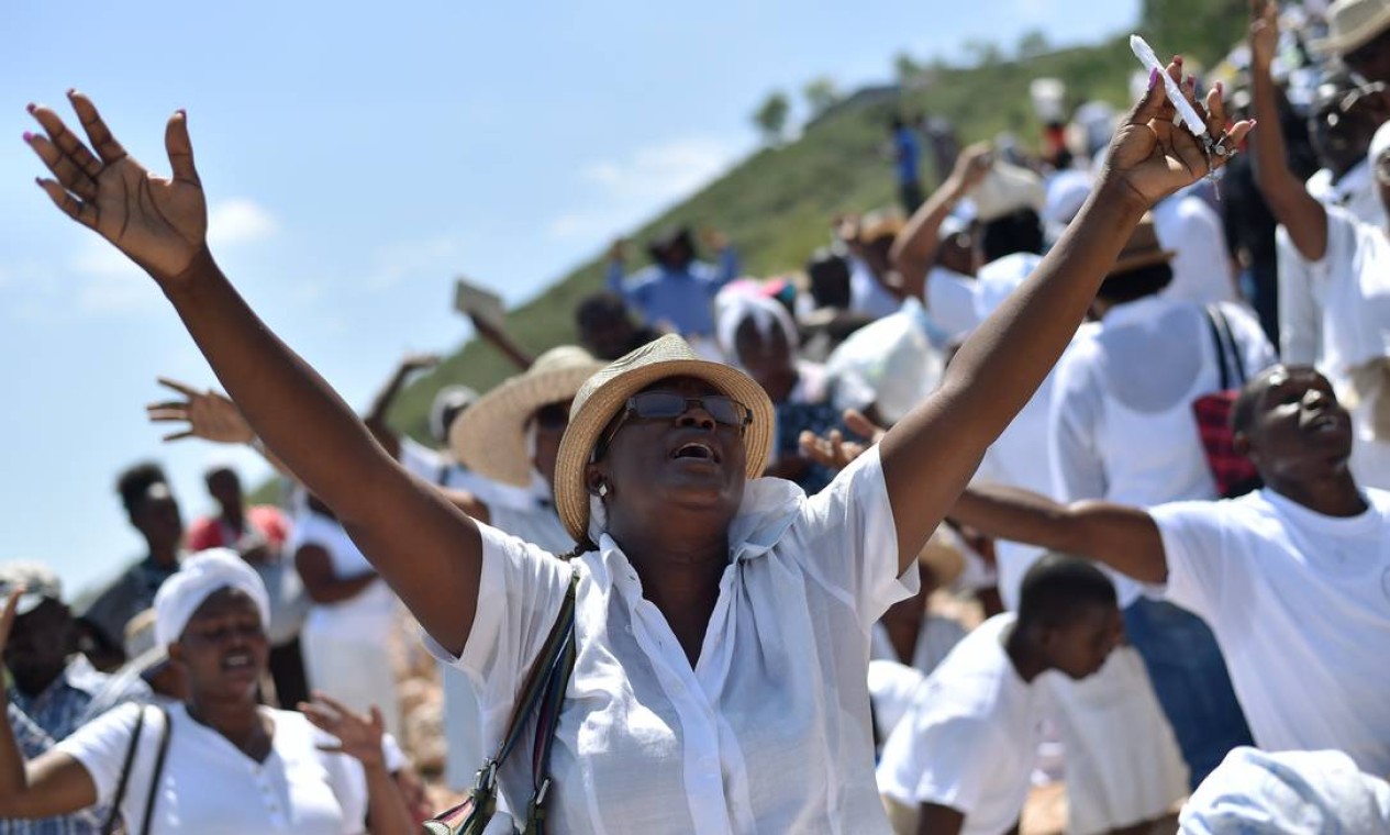 Católicos haitianos rezam e cantam pelas ruas de Ganthier, leste de Porto Príncipe, a capital do país Foto: HECTOR RETAMAL / AFP