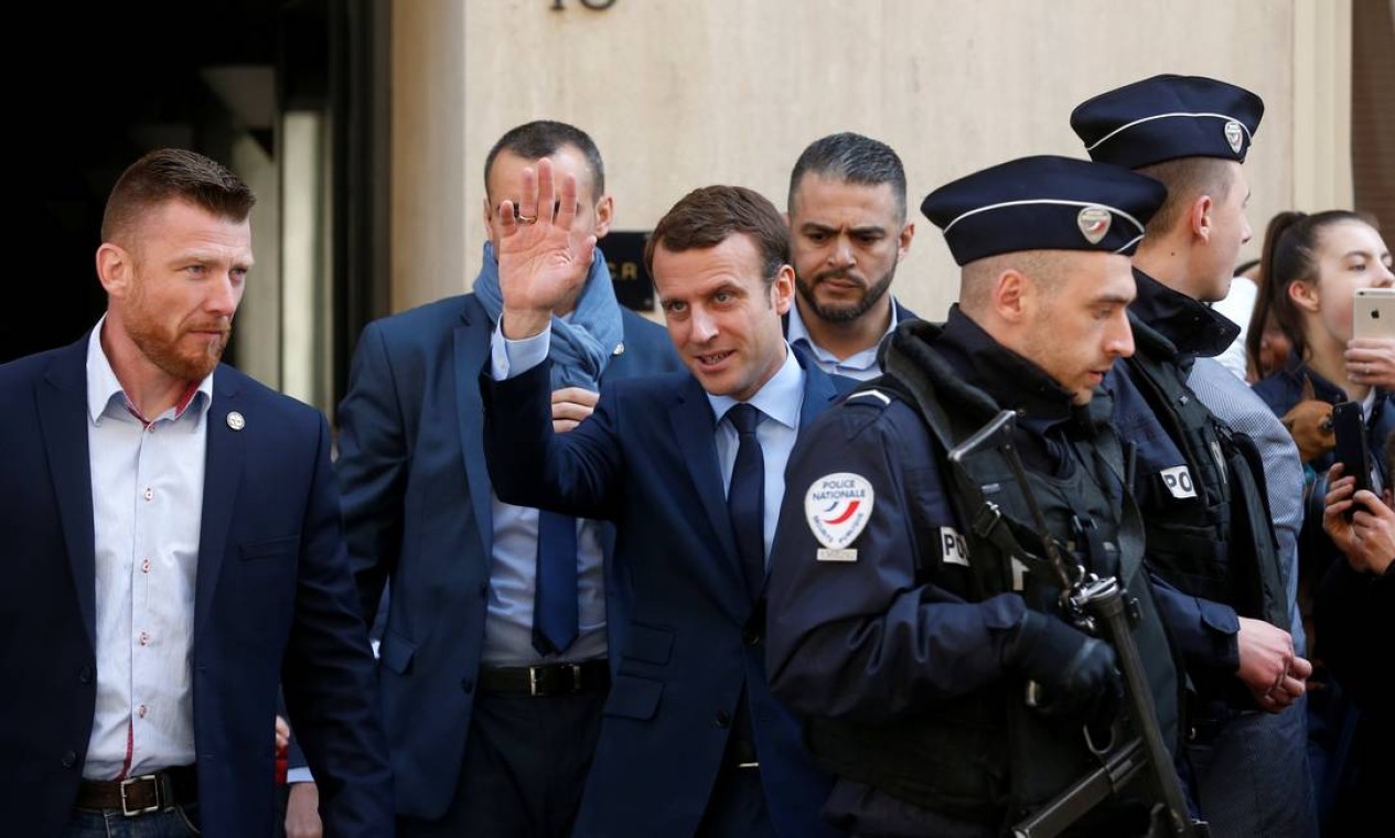 Emmanuel Macron, líder do movimento Em Marcha", acena para franceses enquando deixa sua casa cercado por policiais, em Paris. Ele recebeu o apoio de quase toda a classe política francesa, que defende o voto nele para frear o avanço da extrema-direita Foto: BENOIT TESSIER / REUTERS