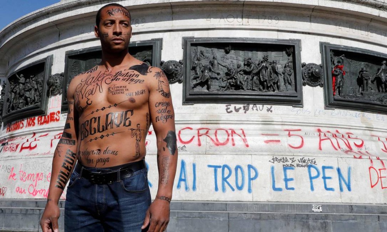 Um homem com o corpo coberto de insultos racistas posa durante um evento organizado pelo Conselho Representativo das Associações Negras da França (CRAN), protestando contra o racismo, na Praça da República Foto: FRANCOIS GUILLOT / AFP