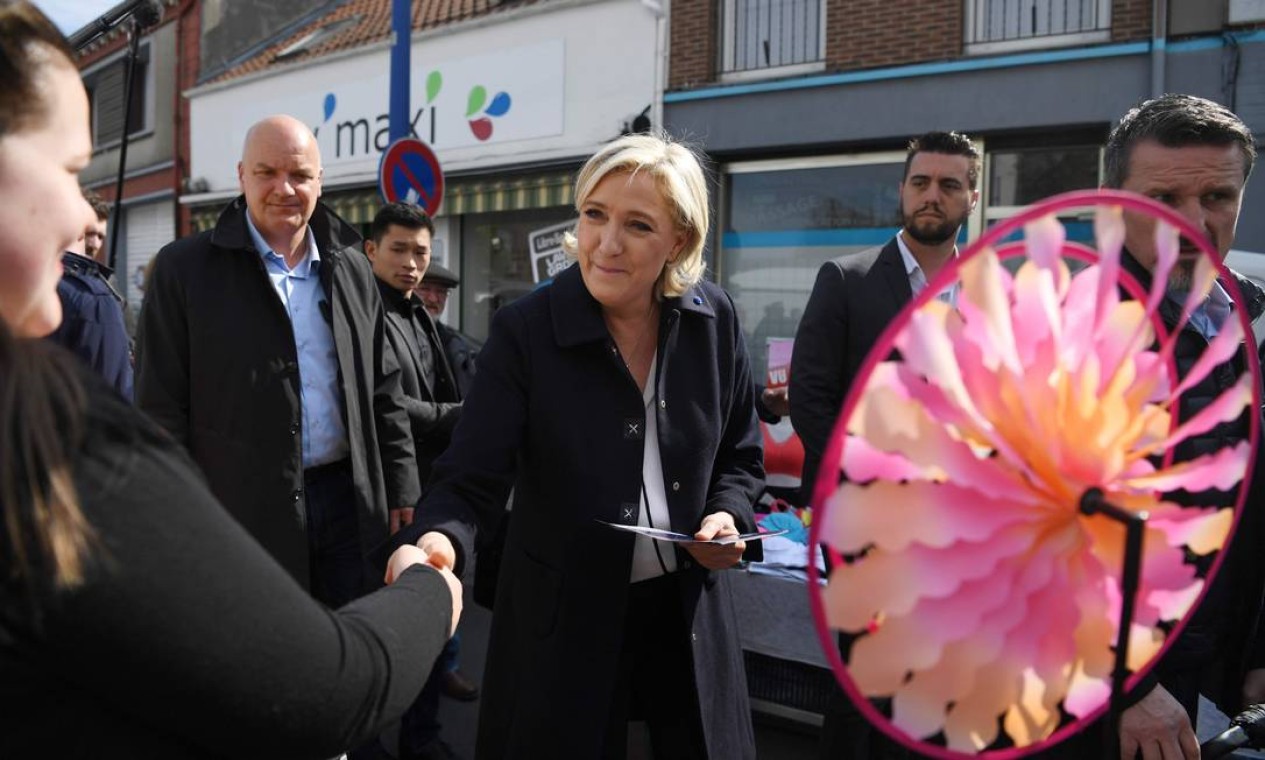 A candidata da extrema-direita, Marine Le Pen, caminha pelo mercado de Rouvroy, no Norte da França, com seu guarda-costas. Le Pen e Macron tentam conquistar o apoio dos outros candidatos e os votos direcionados a eles Foto: ALAIN JOCARD / AFP