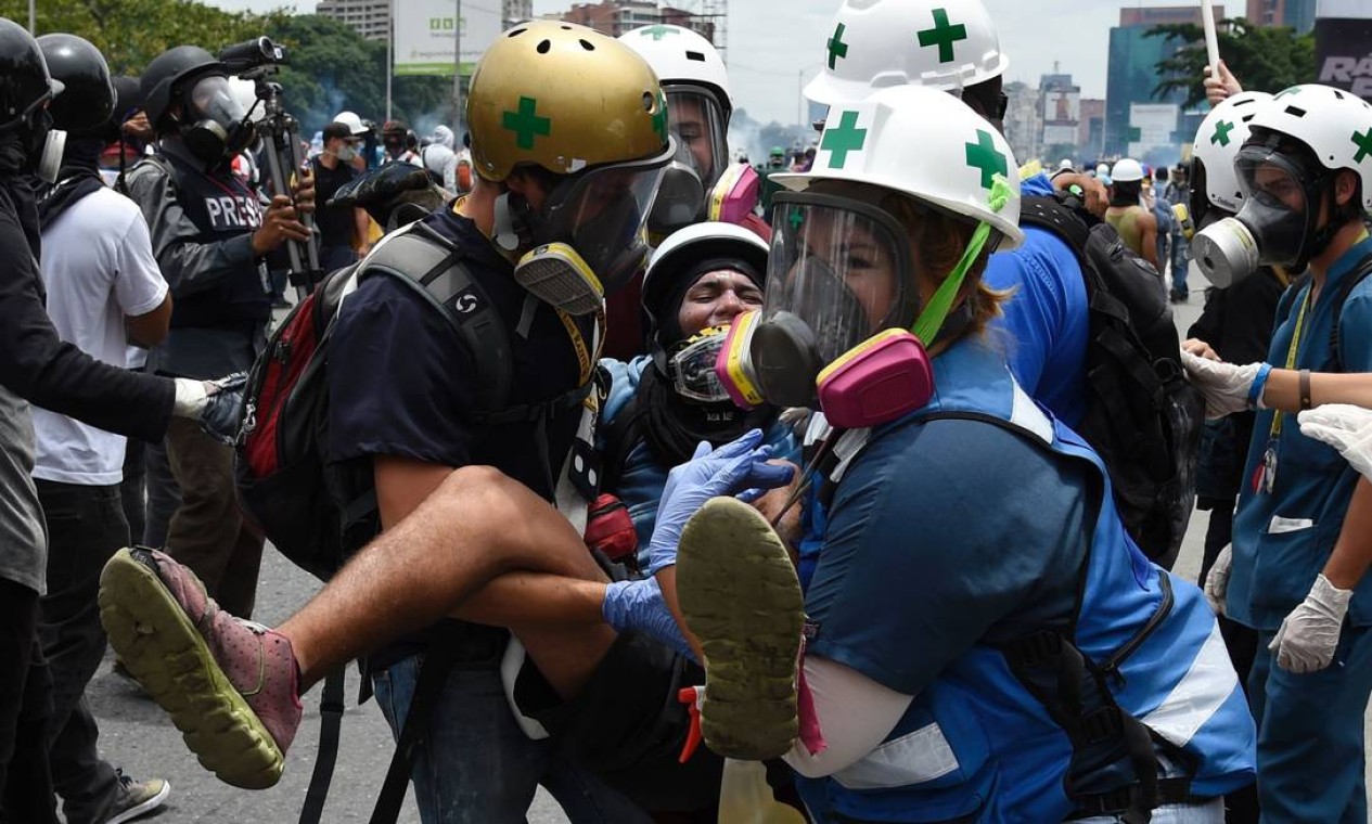 Um manifestante é socorrido após ser ferido durante protesto contra Maduro. A convocação da Assembleia Nacional Constituinte é considerada pelos opositores uma fraude de Maduro para evitar eleições e se fortalecer no poder Foto: JUAN BARRETO / AFP