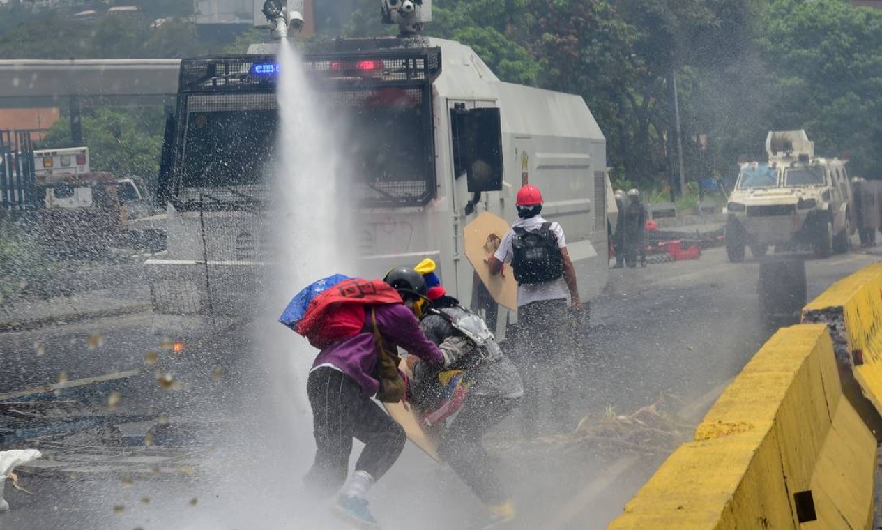 A polícia anti-motim usa jatos d'água contra manifestantes em protesto da oposição, em Caracas. O presidente venezuelano, Nicolás Maduro, entregou nesta quarta-feira ao poder eleitoral o decreto de convocação de uma Assembleia Nacional Constituinte Foto: RONALDO SCHEMIDT / AFP