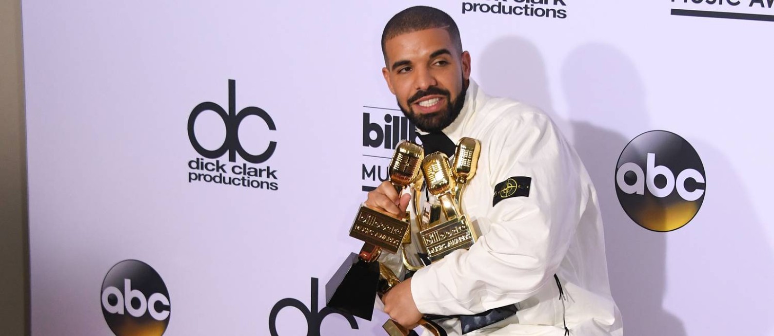 Drake posa ao lado dos 13 prêmios ganhos no Billboard Music Awards 2017 Foto: MARK RALSTON / AFP