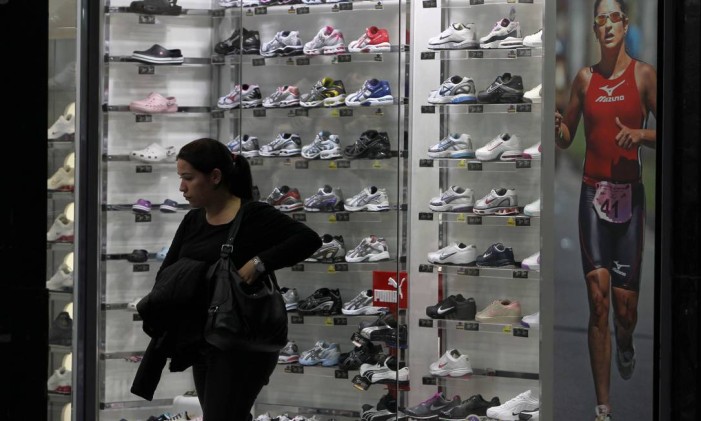 Consumidora analisa preços de tênis em loja no centro de São Paulo antes de comprar Foto: Michel Filho / Agência O Globo