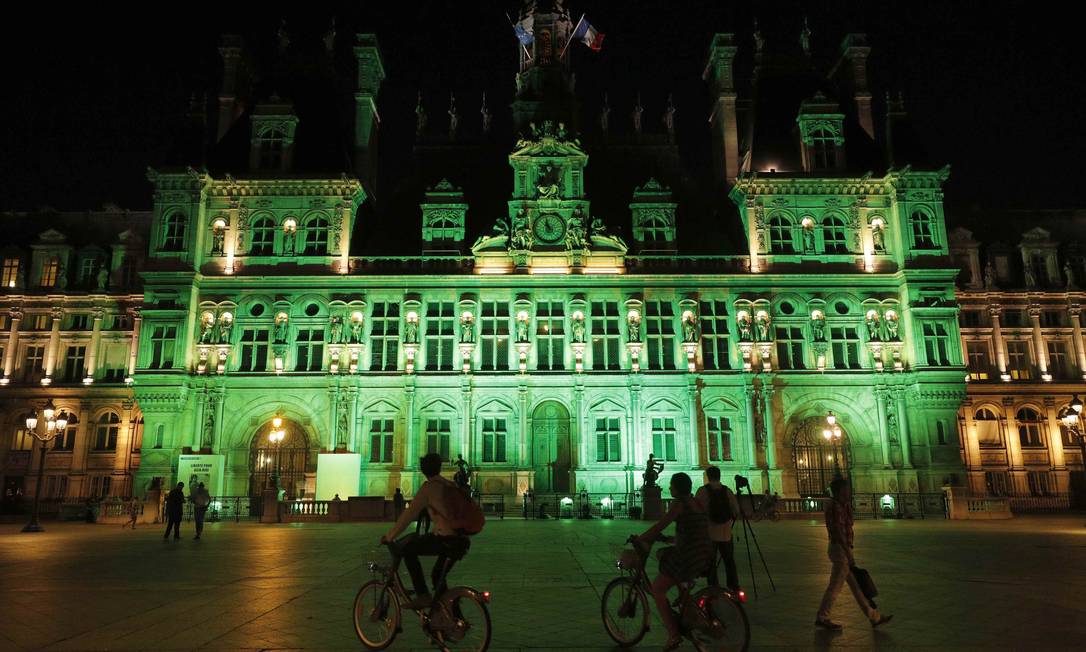 Luzes verdes iluminam o Hotel de Ville, em Paris, em resposta à decisão de Trump de sair do acordo climático de Paris Foto: Philippe Wojazer / Reuters