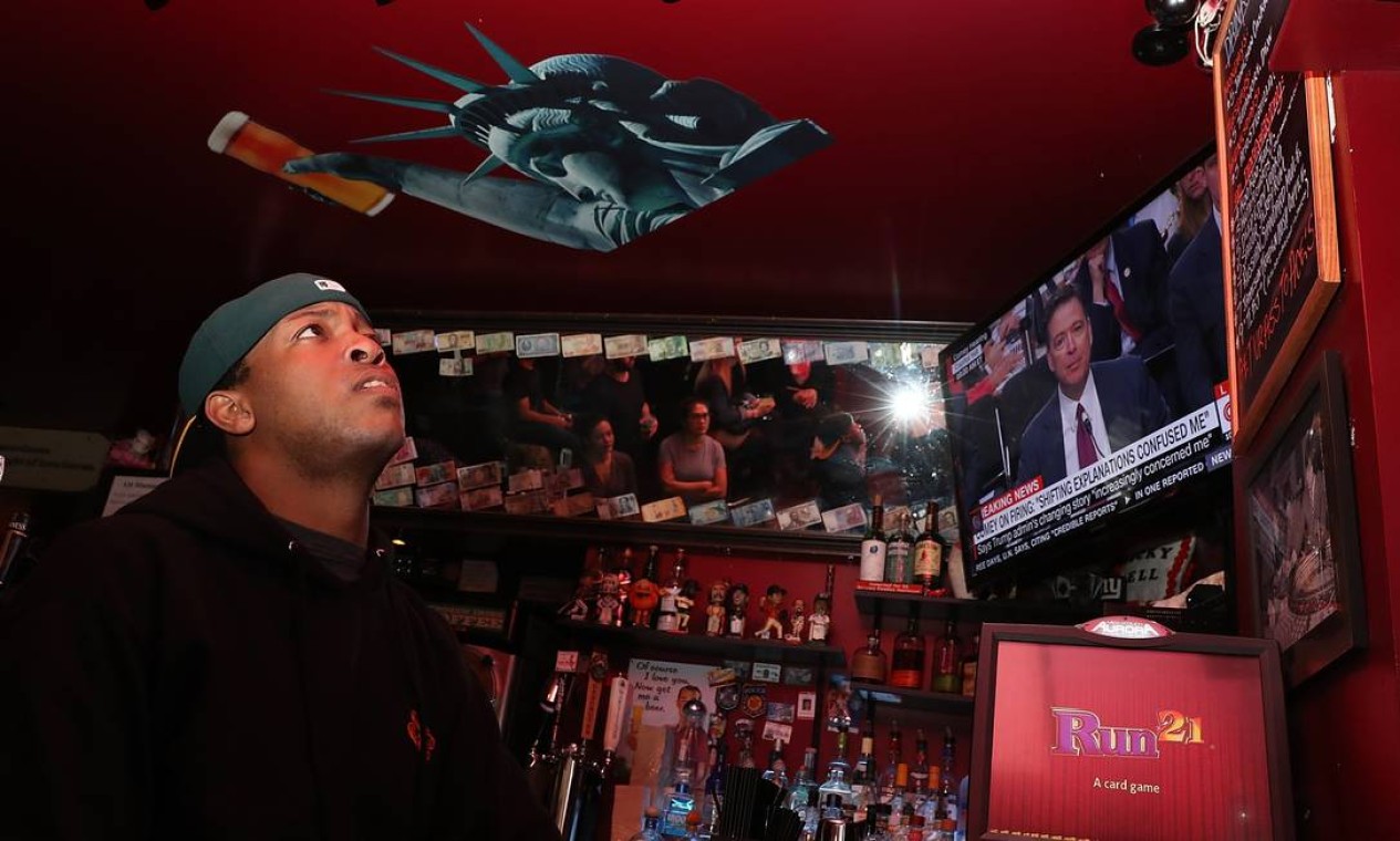 Um funcionário de um bar assiste à transmissão da audiência do ex-diretor do FBI James Comey em San Francisco, na Califórnia Foto: JUSTIN SULLIVAN / AFP