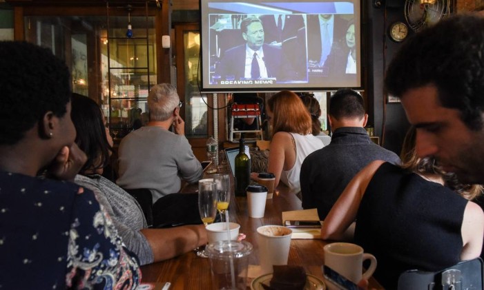 Pessoas assistem o testemunho do ex-diretor do FBI James Comey em um restaurante no Brooklyn, em Nova York. Americanos em todo o país lotaram bares e restaurantes para ver o testemunho de Comey sobre suas conversas com o presidente Donald Trump Foto: STEPHANIE KEITH / AFP