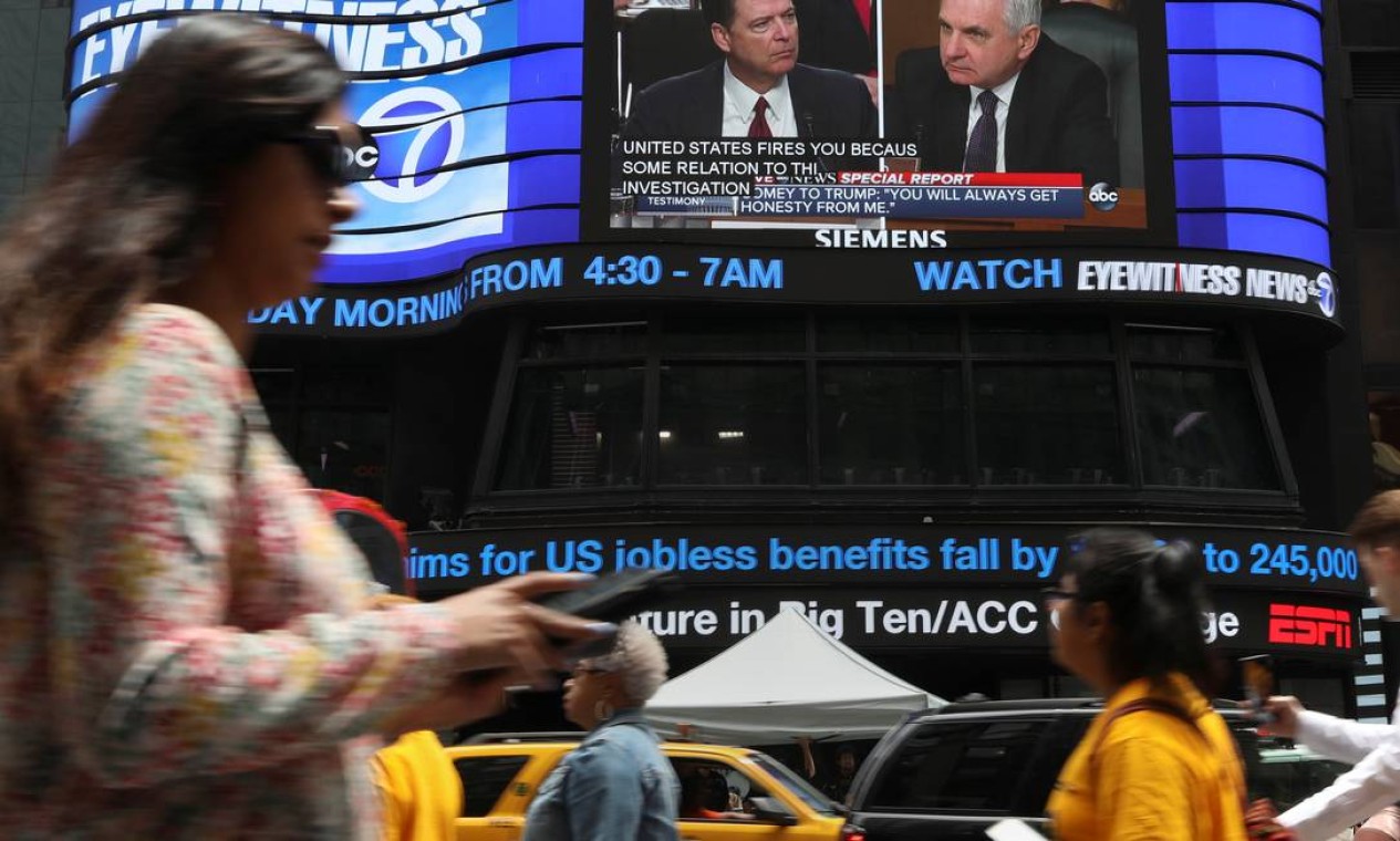 A audiência do ex-diretor do FBI James Comey é transmitida em um telão fora dos estúdios da rede americana ABC, na Times Square, em Nova York Foto: SHANNON STAPLETON / REUTERS