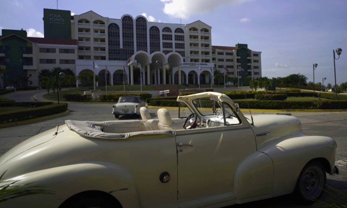 Um carro americano antigo é visto estacionado em frente a um hotel em Havana Foto: Ramon Espinosa / AP
