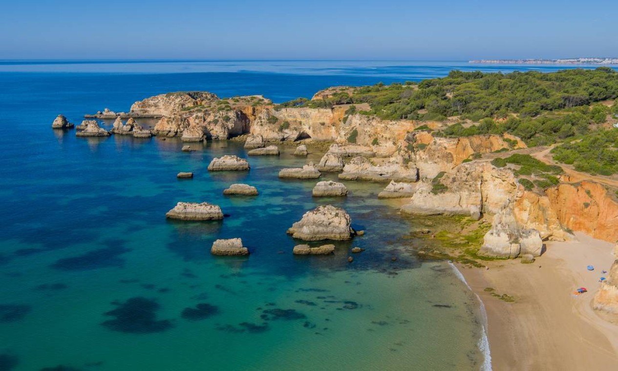 Falésias, rochas e arcos naturais da Praia do Alemão, em Portimão, uma das mais bonitas do Algarve Foto: Associação do Turismo do Algarve / Divulgação