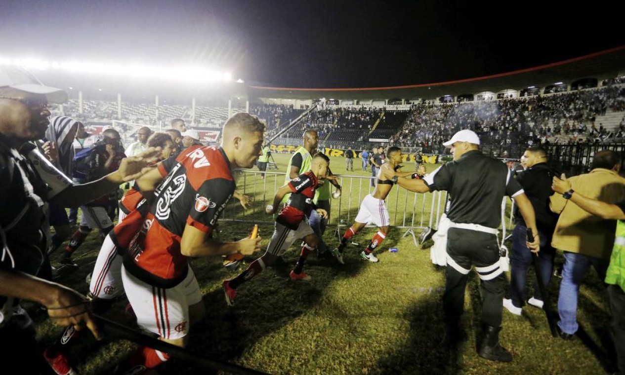 Jogadores do Flamengo correm para deixar o gramado em meio a enorme confusão em São Januário Foto: Antonio Scorza / Agência O Globo