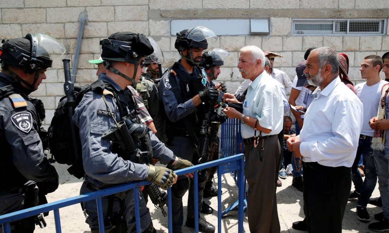 Policais vigiam uma barreira em uma rua próxima à Cidade Velha de Jerusalém Foto: AMMAR AWAD / REUTERS