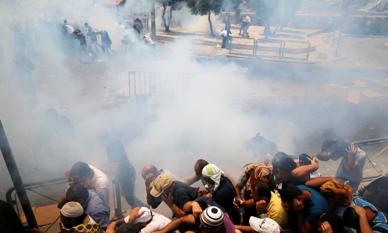Palestinos reagem ao gás lacrimogêneo lançado pelas forças de segurança israelenses, em uma rua próxima à Cidade Velha de Jerusalém Foto: AMMAR AWAD / REUTERS