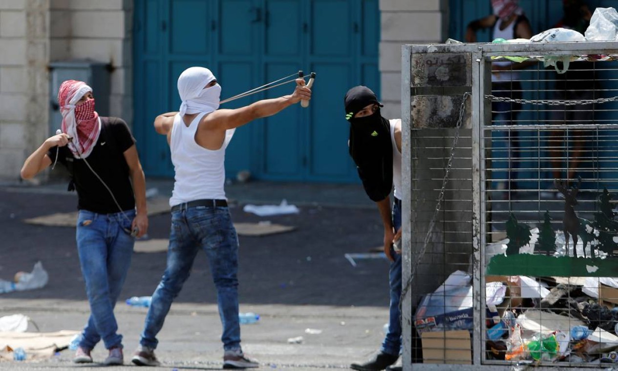 Manifestante usa um estilingue para jogar pedras contra tropas israelenses durante protesto em Belém, na Cisjordânia Foto: MUSSA ISSA QAWASMA / REUTERS