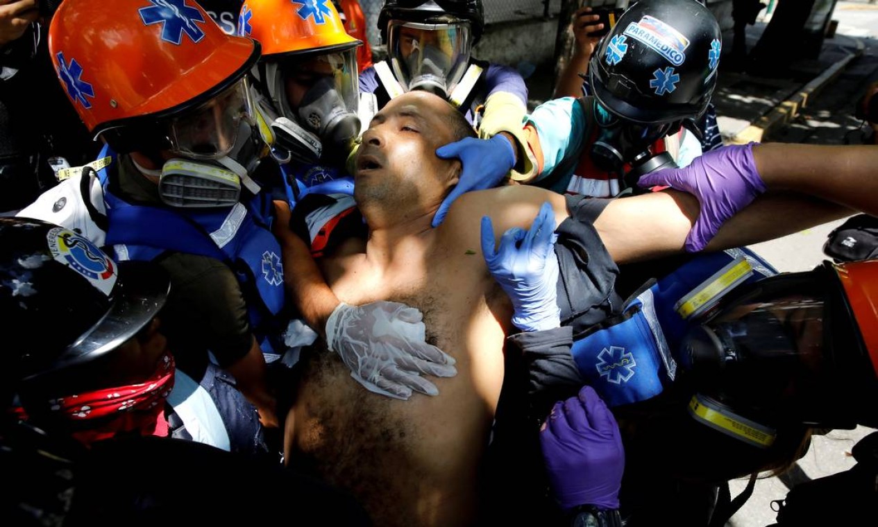 Um homem ferido durante confrontos entre manifestantes e as forças de segurança recebe atendimento médico, em Caracas Foto: CARLOS GARCIA RAWLINS / REUTERS
