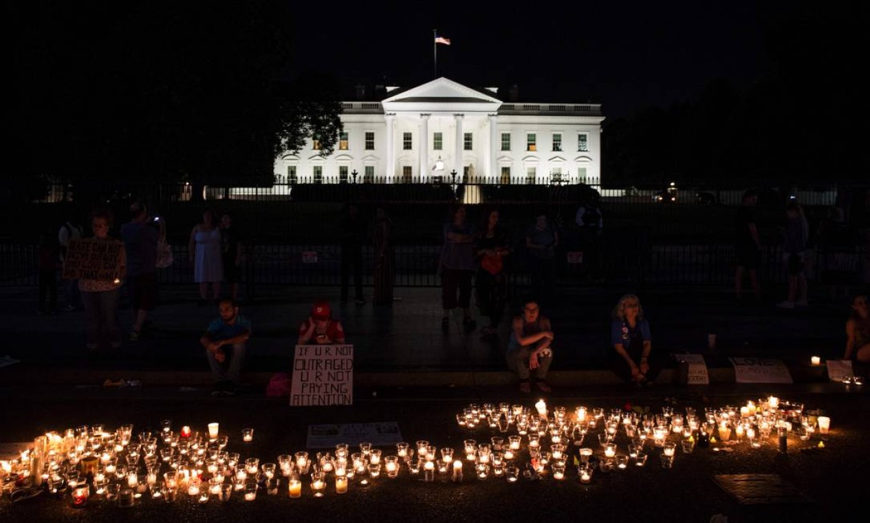 Pessoas se reúnem em frente à Casa Branca, no domingo, 13 de agosto, para vigília em resposta à morte de vítima em Charlottesville Foto: ZACH GIBSON / AFP