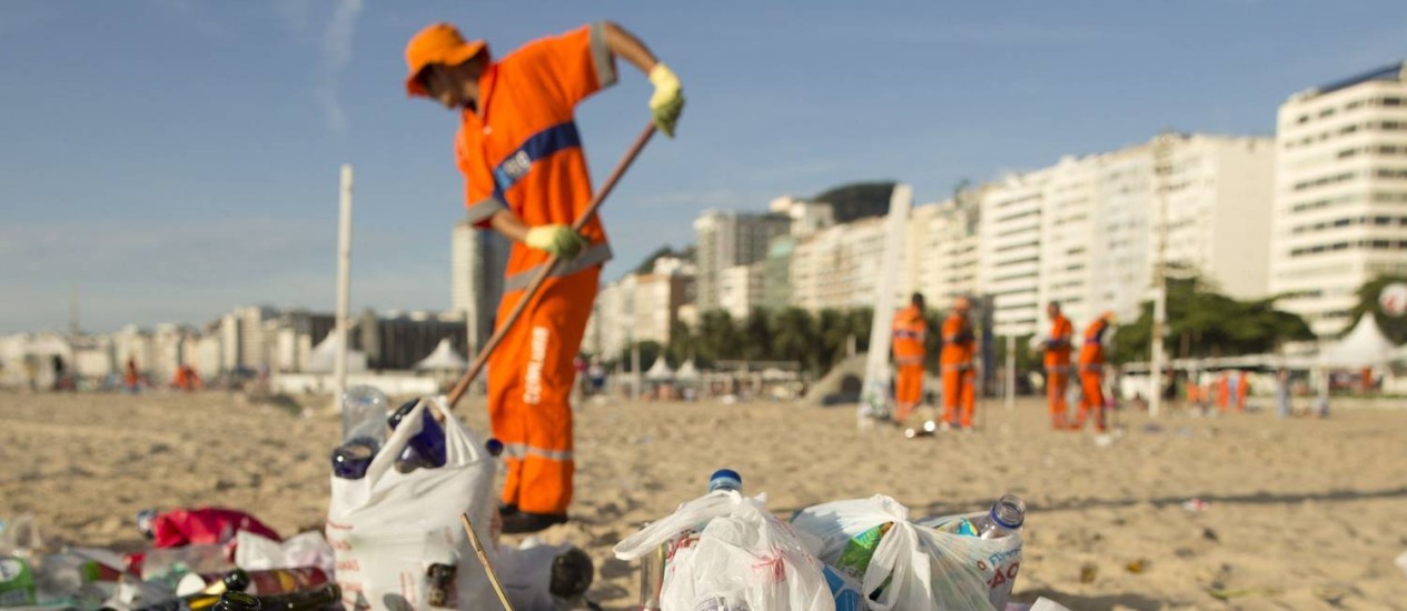 Garis limpam a Praia de Copacabana: recolhimento de lixo pode ser interrompido por falta de dinheiro Foto: Marcia Foletto - 01-01-2016 / Agência O Globo