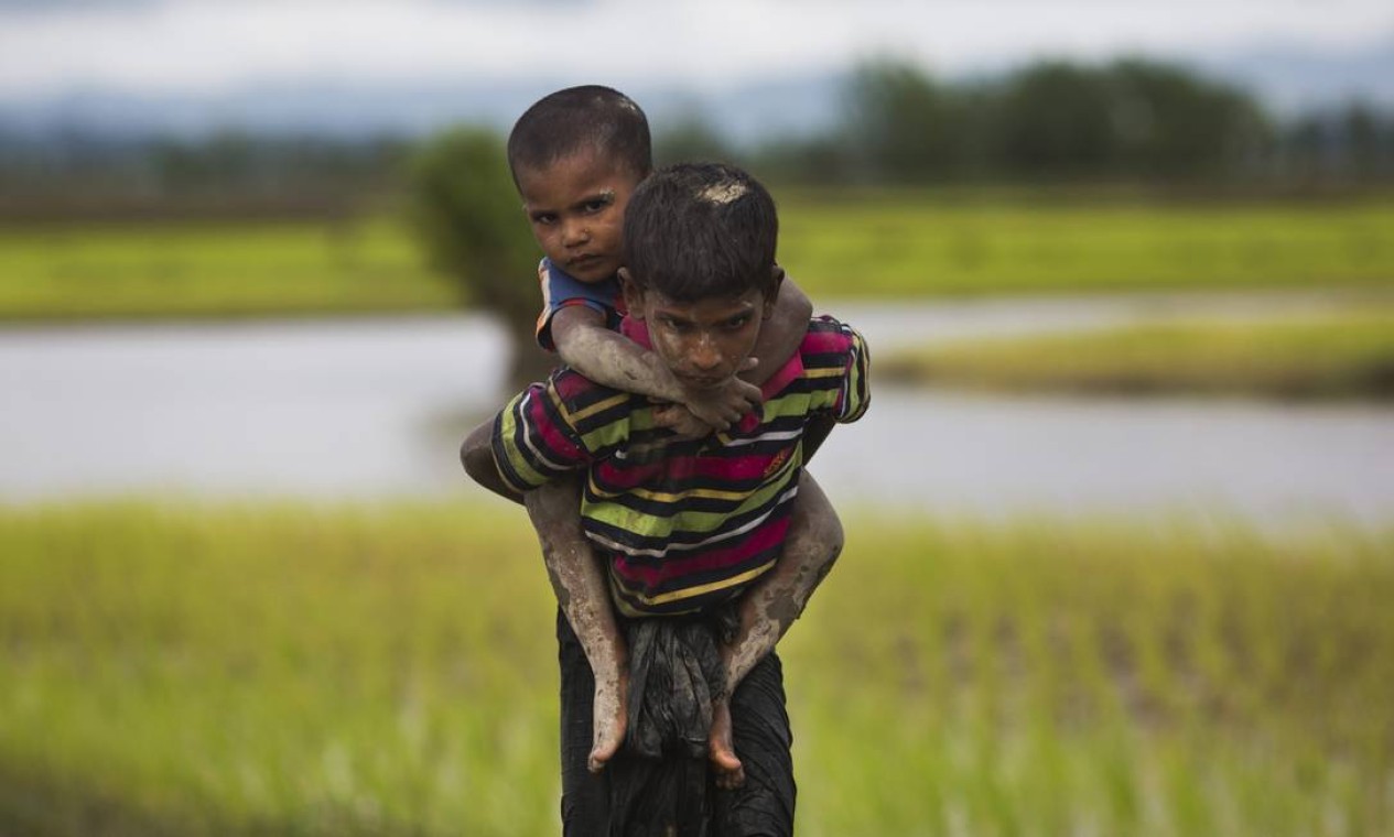 Crianças da etnia rohingya caminham por campos de arroz após cruzar a fronteira de Mianmar para Bangladesh; quase 400 morreram em onda de violência em agosto entre os rebeldes muçulmanos rohingyas e o Exército birmanês Foto: Bernat Armangue / AP