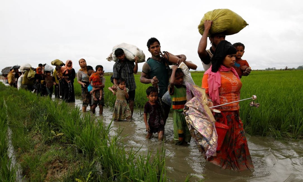 Refugiados atravessam rota de fuga com as pernas na água; caminho para deixar Mianmar é perigoso e cheio de obstáculos Foto: MOHAMMAD PONIR HOSSAIN / REUTERS