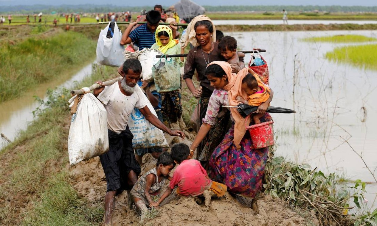 Crianças caem na lama durante travessia para Bangladesh; riscos aumentam no período de chuva de monções Foto: MOHAMMAD PONIR HOSSAIN / REUTERS