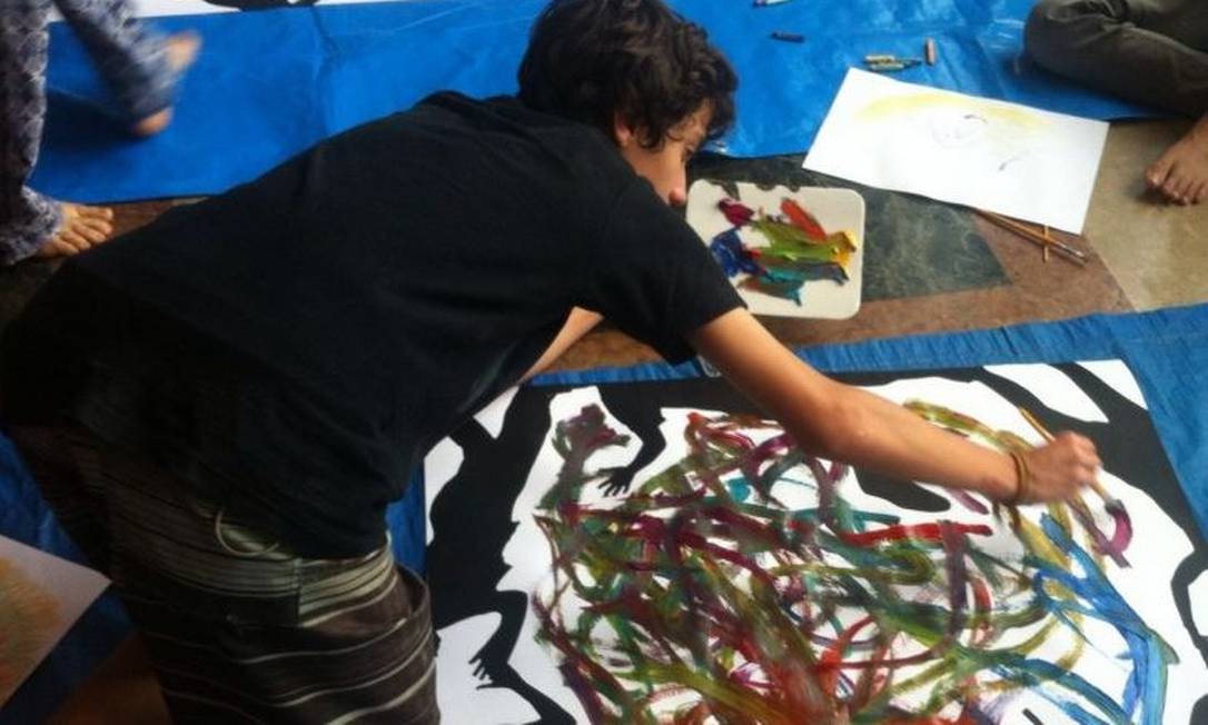 Pintura. Um dos adolescentes em ação: o Jacarezinho para o asfalto ver Foto:
/
Divulgação
