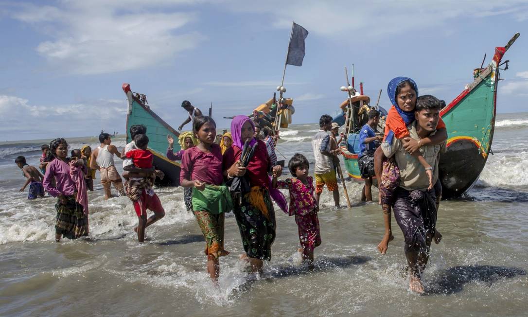 Muçulmanos rohingya deixam embarcação precária após chegar de Mianmar a Bangladesh, na fuga da perseguição Foto: Dar Yasin / AP