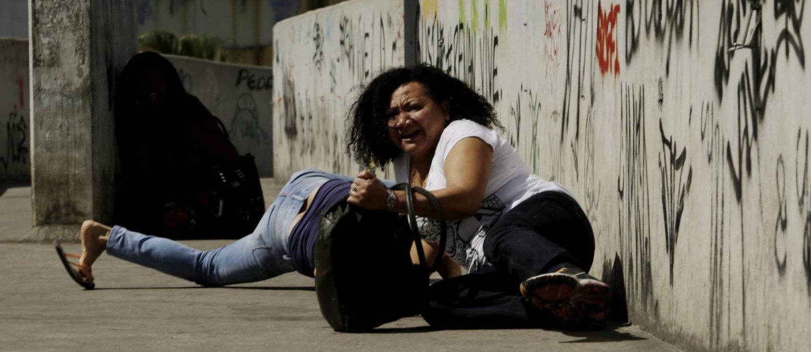 Mulheres se jogam no chão de passarela durante tiroteio na Rocinha Foto: Gabriel Paiva / Agência O Globo