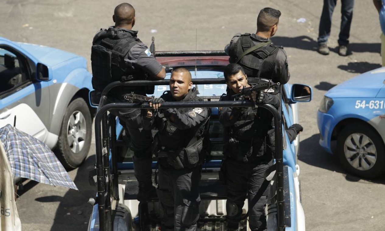Em viatura, policiais militares patrulham com fuzis um dos acessos à comunidade, em São Conrado Foto: Gabriel Paiva / Agência O Globo