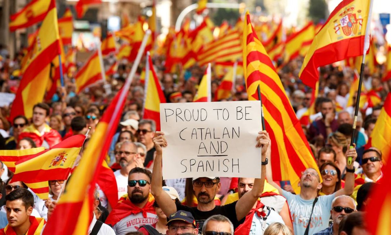 "Orgulhoso de ser catalão e espanhol", diz cartaz erguido por manifestantes Foto: ALBERT GEA / REUTERS