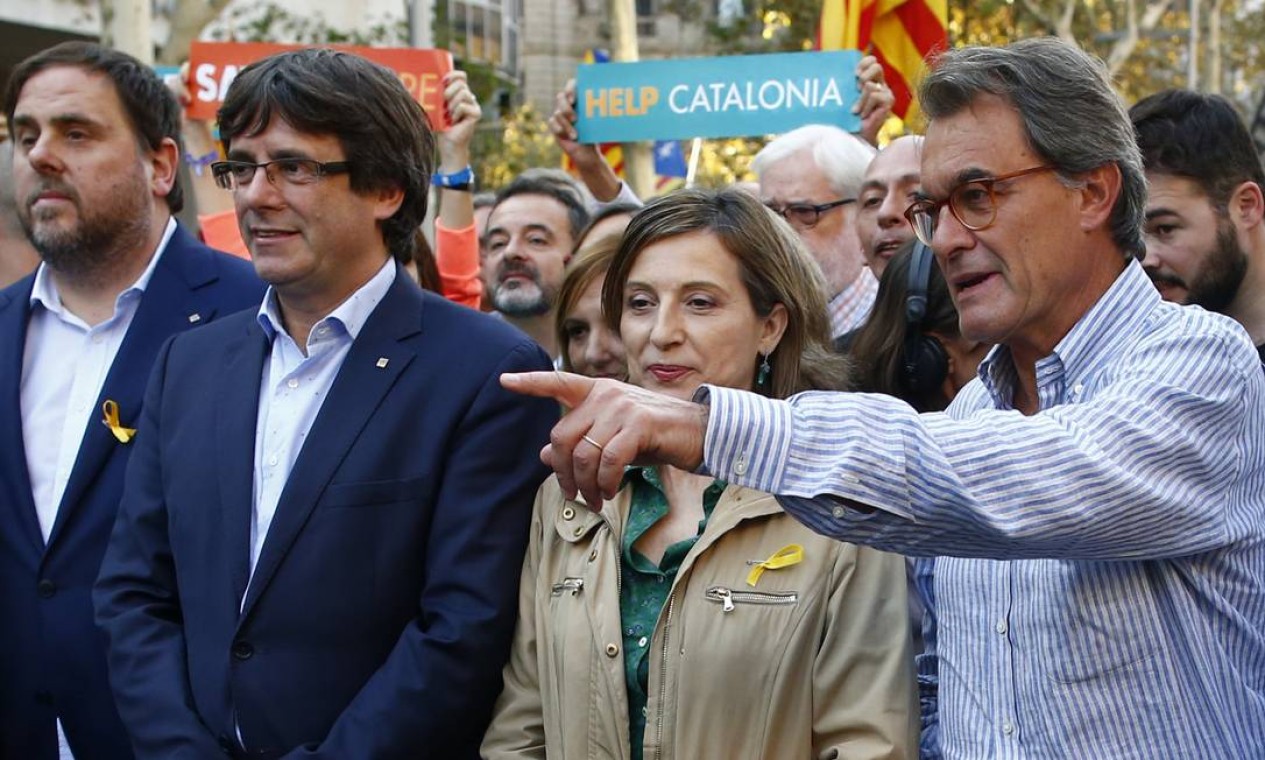 O ex-presidente do governo regional catalão, Artur Mas (à direita), junto ao atual Carles Puigdemont (de óculos e terno azul), e o vice-presidente regional Oriol Junqueras durante passeata pelas ruas de Barcelona Foto: Manu Fernandez / AP