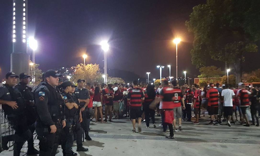 
Policiais observam a entrada de torcedores do Flamengo no Maracanã
Foto:
/
Carolina Oliveira Castro/Agência O Globo
