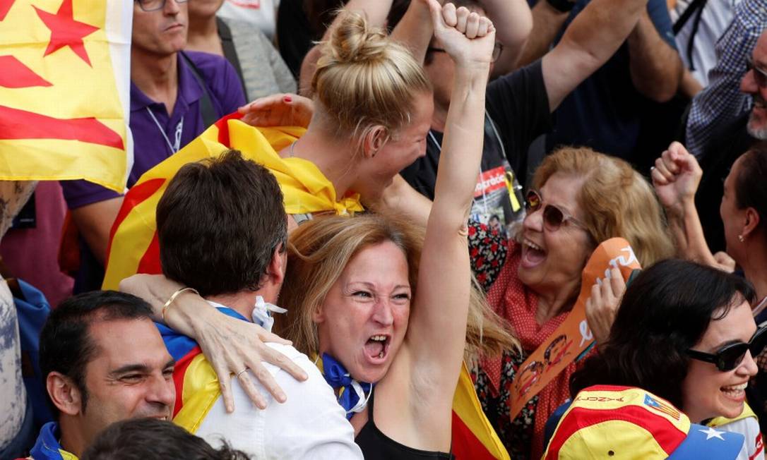 Manifestantes se abraçam do lado de fora do Parlamento catalão Foto: YVES HERMAN / REUTERS