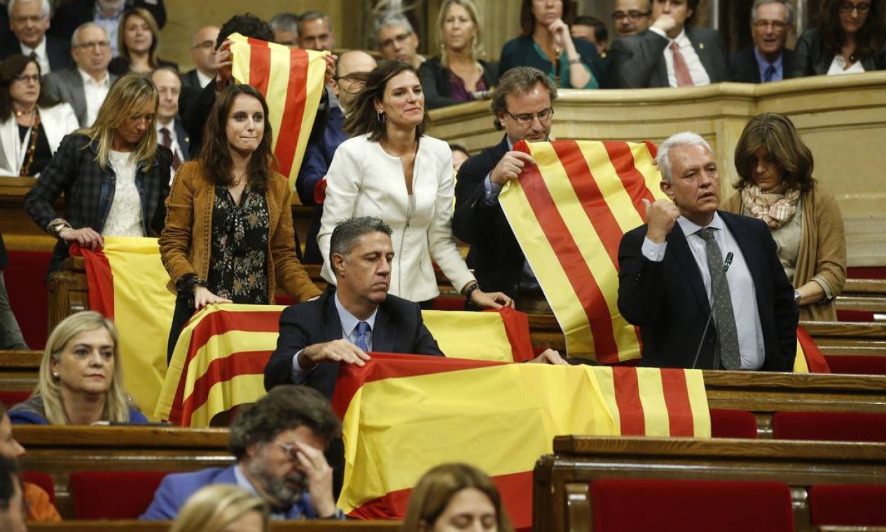 Oposição catalã, que é contra a separação, levou bandeiras espanholas à sessão do Plenário antes do voto sobre a independência Foto: Manu Fernandez / AP