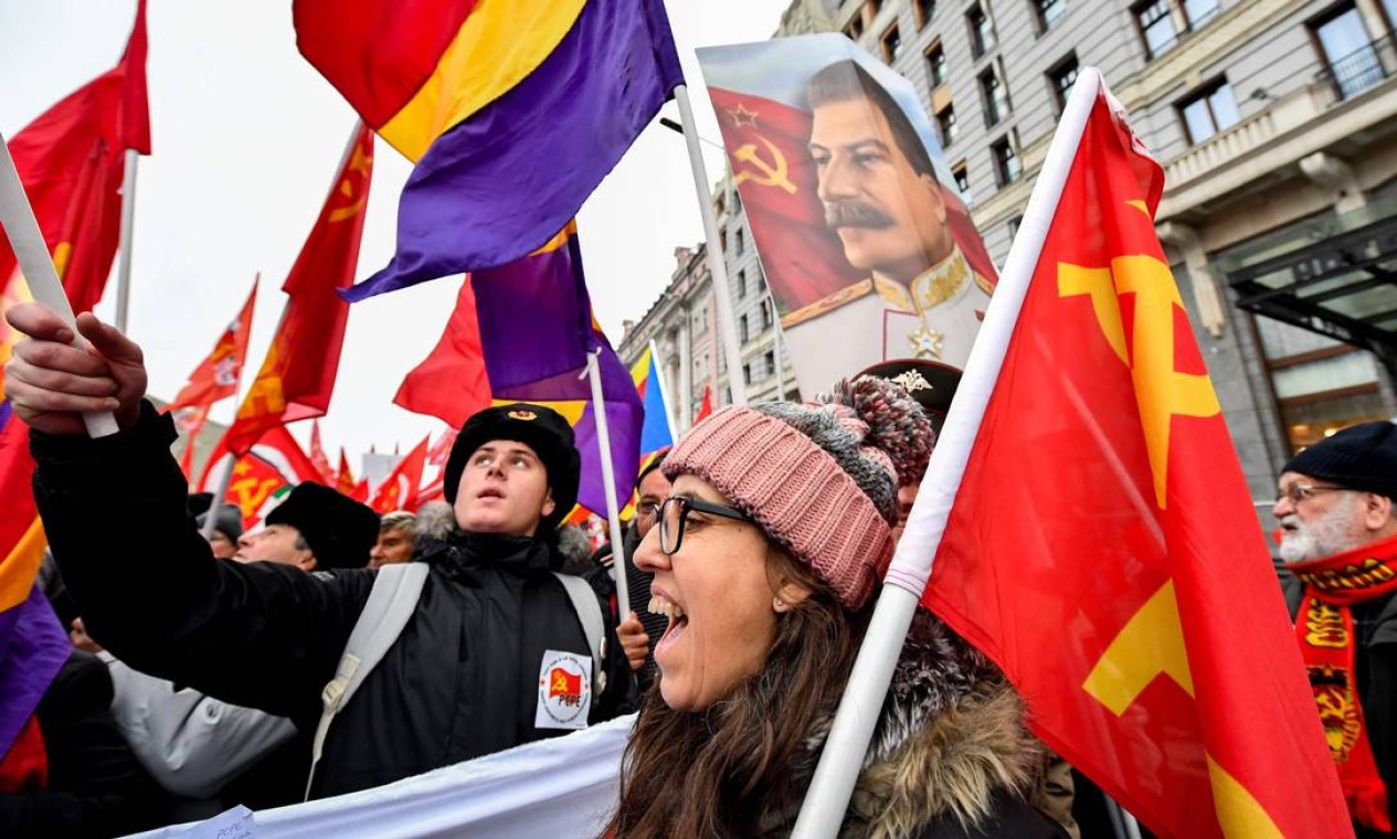 Russos carregam bandeiras e pôsteres de Joseph Stalin durante marcha de cem anos da Revolução Russa. Em Moscou, manifestações foram tímidas Foto: YURI KADOBNOV / AFP