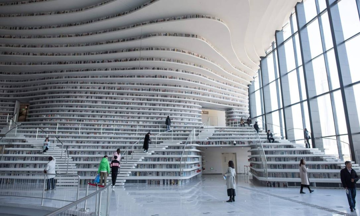 Desde sua inauguração, em outubro de 2017, a biblioteca Binhai, em Tianjin, na China, vem encantando os frequentadores com suas estantes brancas e onduladas, que vão do chão ao teto. Foto: FRED DUFOUR / AFP