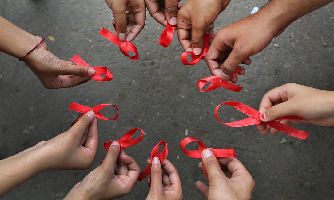 
Ativistas seguram laços de fita vermelha, símbolos da luta contra a Aids: epidemia pode ter piorado no Brasil
Foto:
AP/Aijaz Rahi
