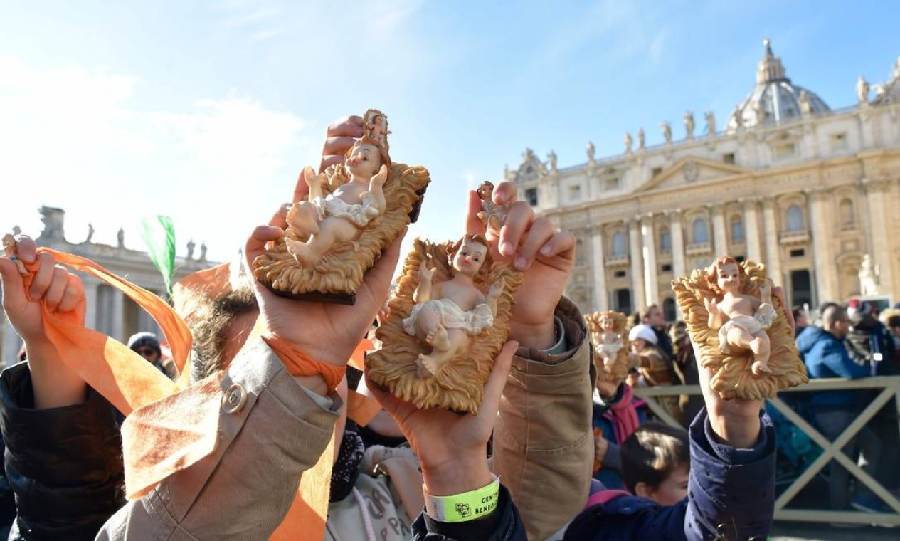Fiéis seguram imagens de Jesus em ritual tradicional do Vaticano antes do Natal, em que se comemorou também aniversário do Papa Francisco Foto: ANDREAS SOLARO / AFP