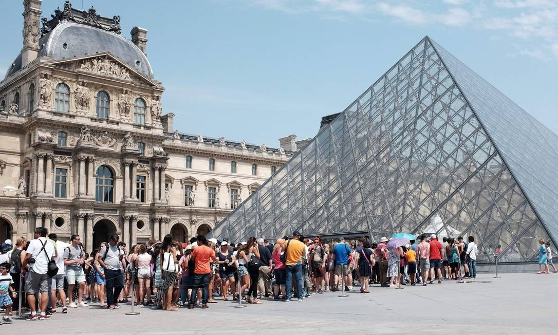 Turistas fazem fila para entrar no Louvre, no verao parisiense: mais de oito milhões de visitantes foram ao museu em 2017 Foto: MIGUEL MEDINA / AFP